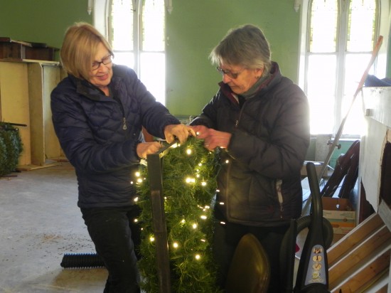 Meredith hanna and Maureen Ecclesine restring one of the 21 Holiday wreaths