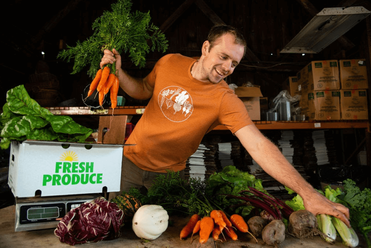 Adam Reed packs a Fair Share CSA box for delivery, Tangleroot Farm, Essex NY