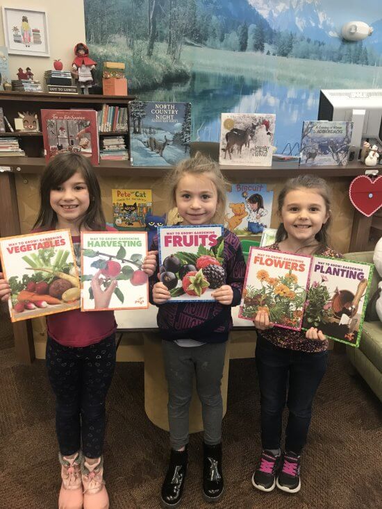 Au Sable Forks Elementary used their Adirondack Garden Club grant to purchase a series of books having to do with different aspects of gardening. Pictured left to right are kindergarteners from Ms. Barber's class and Mrs. Richard's class: Evana Adams, Milo Blaney, Kaelyn Mussaw. Photo by Caroline Douglas.